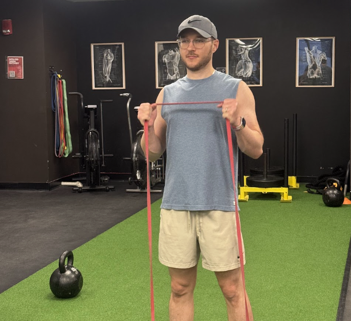 Coach demonstrating a resistance band exercise in the studio
